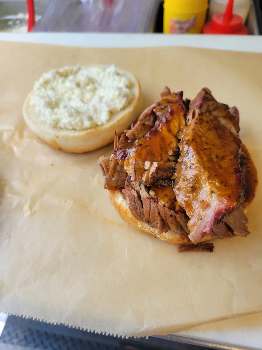 Sliced smoked BBQ sandwich with slaw on butcher paper