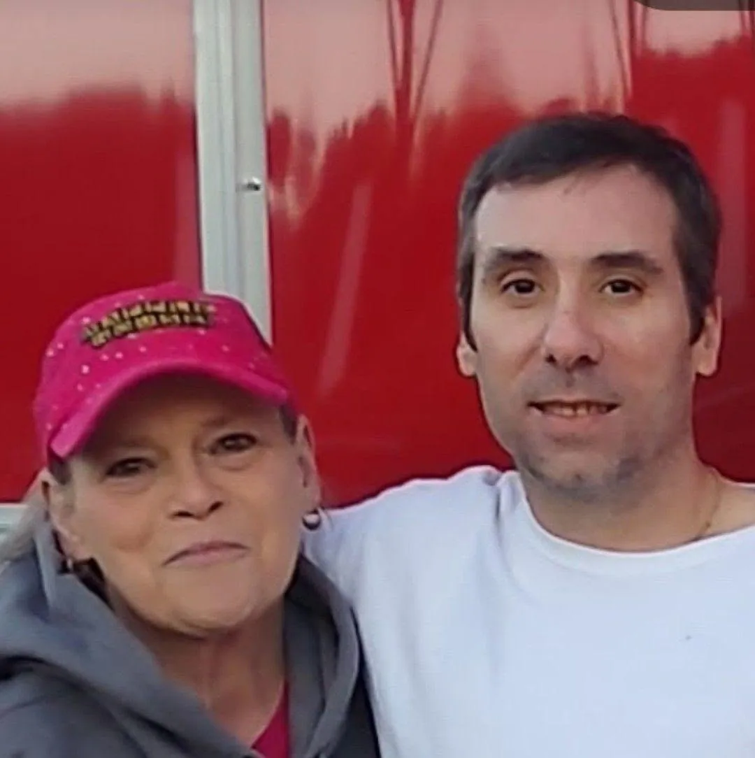 The owners smiling together in front of the red trailer